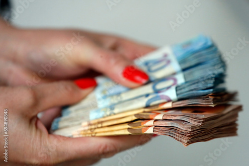 Woman holding euro money banknotes, concept of stealing cash, rich people, savings or spending money, counting payment photo