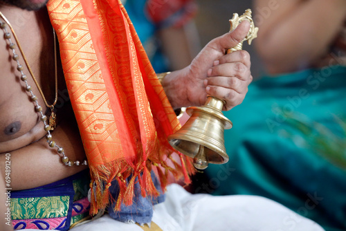 Hand holding ceremonial bell, Sri Srinivasa Perumal Hindu temple, Hindu priest (Brahmin) performing puja ceremony and rituals, Singapore photo