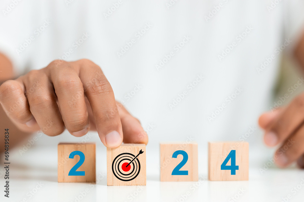 2024 goals business concept. Wooden cubes with Text 2024 with hand holding goal icon. Happy new year 2024. Planning business and lifestyle goals for next year. 2024 goals business concept. Wooden cubes with Text 2024 with hand holding goal icon. Happy new year 2024. Planning business and lifestyle goals for next year.
