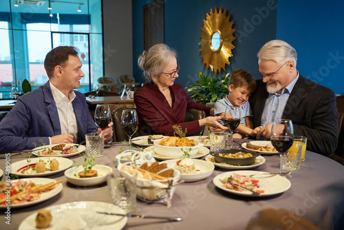 Happy family having festive dinner and celebrating Hanukkah at dining table