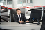 Man dealer sitting at workplace offers car sales contracts in dealership office