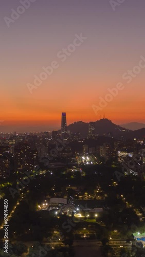 Sparkling Santiago City at Sunset. Aerial Hyper Lapse, Time Lapse. Evening Twilight. Blue Hour. Las Condes Commune. Chile. Drone Flies Sideways and Upwards. Vertical Video photo