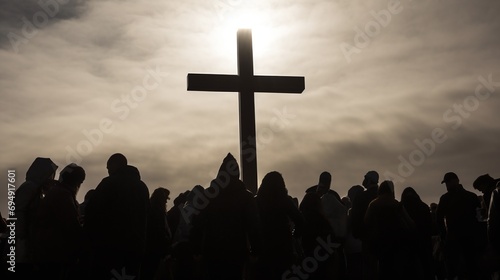 Silhouetted Group of People Gathered Around a Large Cross at Sunset with Dramatic Sky Background