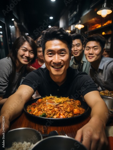 At a family New Year s dinner. Happy young Asian people sitting in a restaurant and taking photos.