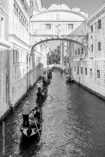 Black and white view of a row of gondolas under the famous Ponte dei Sospiri, Bridge of Sighs in Venice, Italy 