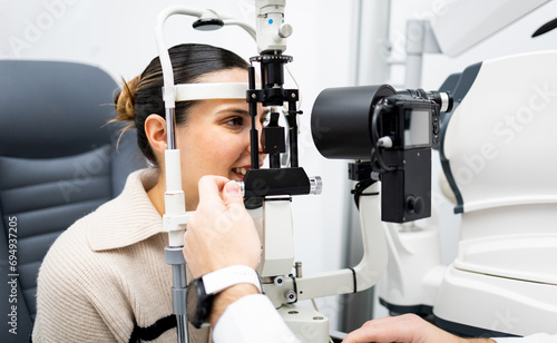 Fotografia An unrecognizable ophthalmologist uses a slit lamp with a camera to examine a woman's eye