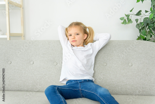 Blond girl sit on sofa at home