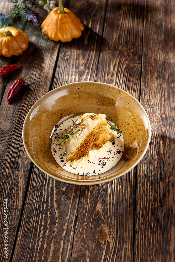 Baked cabbage steak in a velvety cream sauce, served in an artisanal bowl on a rustic wood table Baked cabbage steak in a velvety cream sauce, served in an artisanal bowl on a rustic wood table