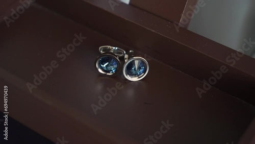 Men's cufflinks on wooden table. Male fashion. Morning of the groom on the wedding day. Clothes for a holiday or event. photo