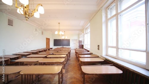 Empty small classroom with wooden desks and chandeliers  photo