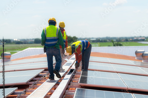 engineer men inspects construction of solar cell panel or photovoltaic cell by electronic device. Industrial Renewable energy of green power. factory worker working on tower roof.