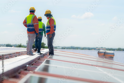 engineer men inspects construction of solar cell panel or photovoltaic cell by electronic device. Industrial Renewable energy of green power. factory worker working on tower roof.