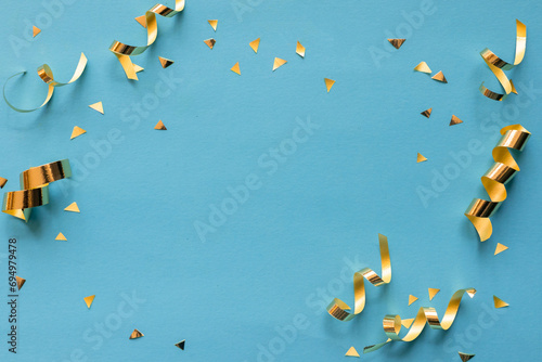 close up on group of gold color of rolling ribbon and confetti on teal background with copy space for christmas festival happy new year ,carnival , birthday and anniversary, concept design photo