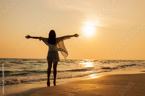 Beautiful young asian woman relax smile leisure around beach sea and enjoying sunset on the beach in Thailand.