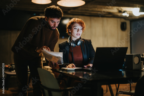 Confident young business people collaborating late at night in a creative office, discussing global market expansion and driving the success of their start-up group.