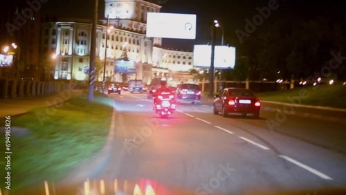 Cars and motorcycle ride under bridge on night street photo