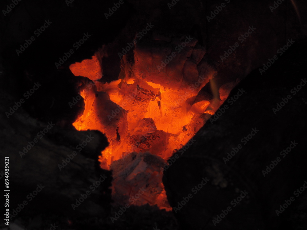 Yellow and orange flames over the embers of a winter bonfire Yellow and orange flames over the embers of a winter bonfire