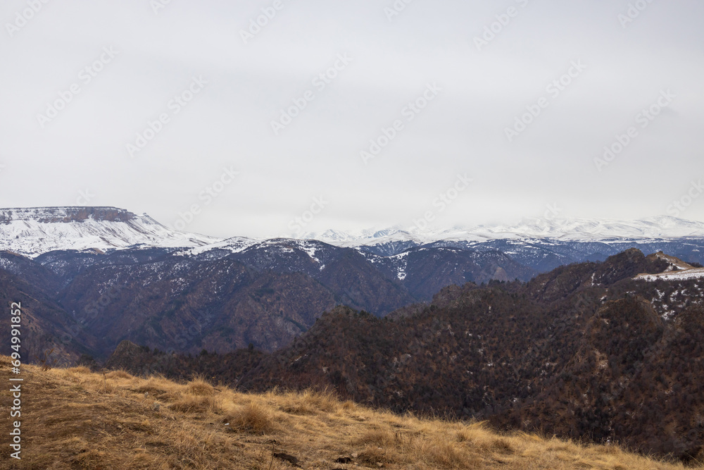An open fenced area with a beautiful panoramic view of snow-covered mountain peaks.