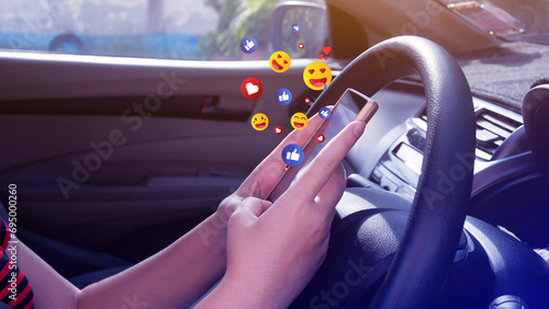 Social media and online digital concept, woman using smart phone sending emojis with social media in car. © rawintanpin