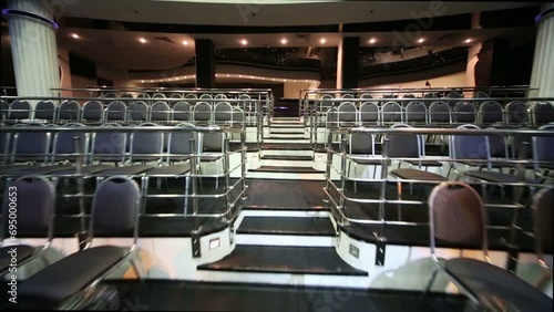 Stairs among rows of seats in empty illuminated auditorium photo