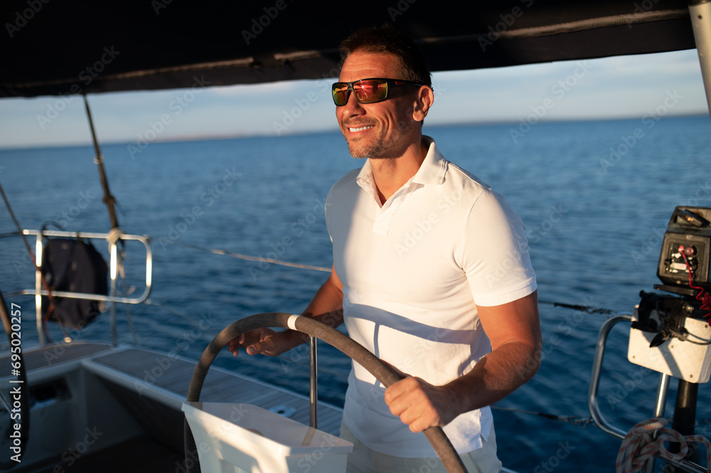 Short-haired confident mature man sailing on a yacht