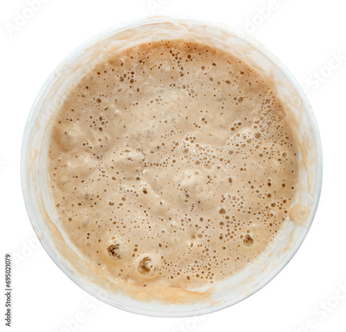 Dough in a plate on a white background. View from above. Semi-finished product for baking. Fermentation of dough with bubbles photo