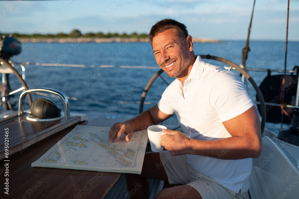 Good-looking positive man on a yacht feeling good Good-looking positive man on a yacht feeling good