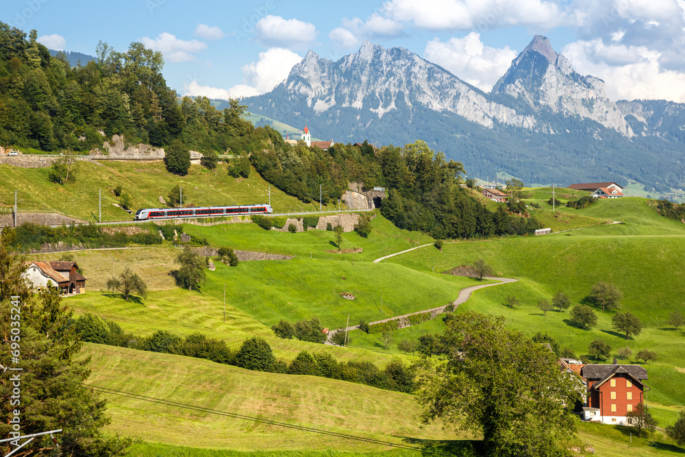 Passenger train type Stadler Flirt of Südostbahn at Grosser Mythen mountain in the Swiss Alps in Arth, Switzerland