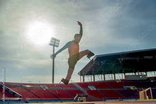 Front view of sport man athlete prosthesis legs jump up in front of sun light in the afternoon of the stadium.