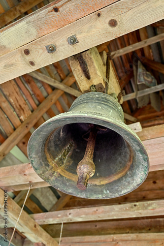 Old cast metal bell, view from below into the wooden roof of the church