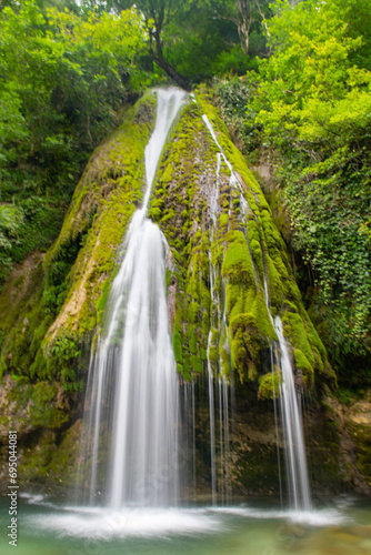 Soft water on the background of green trees photo