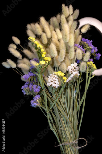 Bouquet of dried flowers. Lagurus ovatus and Limonium on a black background