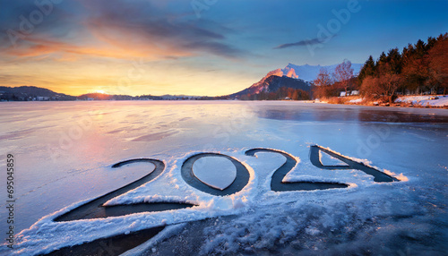 2024 written on the frozen lake, beautiful winter mountain landscape. photo