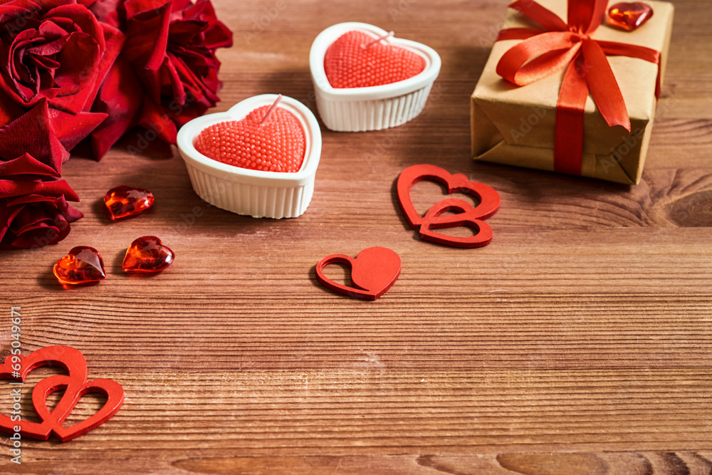 Valentines day frame with gift box and red roses, candles on a wooden background. Valentines day banner with copy space Valentines day frame with gift box and red roses, candles on a wooden background. Valentines day banner with copy space