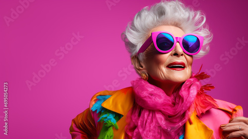 Happy senior woman in colorful outfit, cool sunglasses, laughing and having fun in fashion studio