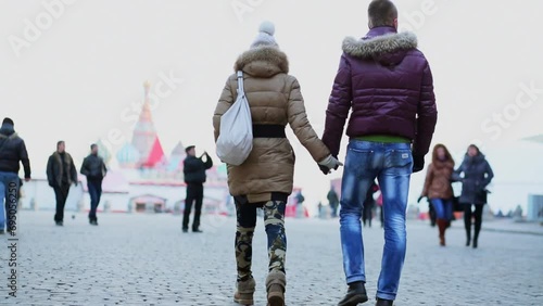 man and woman walk by Red Square near Spasskaya Tower photo