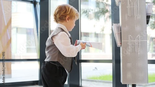 Little boy in business clothes with magazine in business center  photo