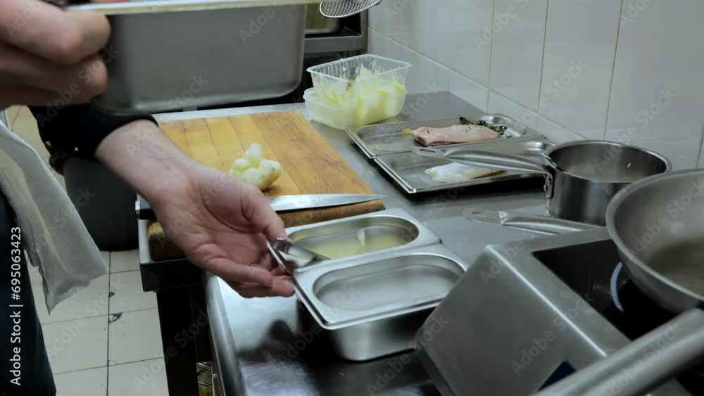 The cook cooks in the kitchen of the restaurant, the kitchen and kitchen utensils, the hands of the cook at work The cook cooks in the kitchen of the restaurant, the kitchen and kitchen utensils, the hands of the cook at work