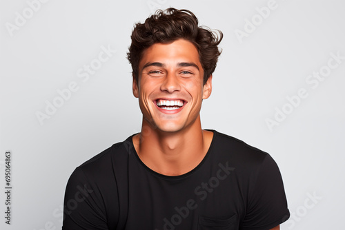 Smiling man with curly hair and black t-shirt, radiating joy and charisma. White Background