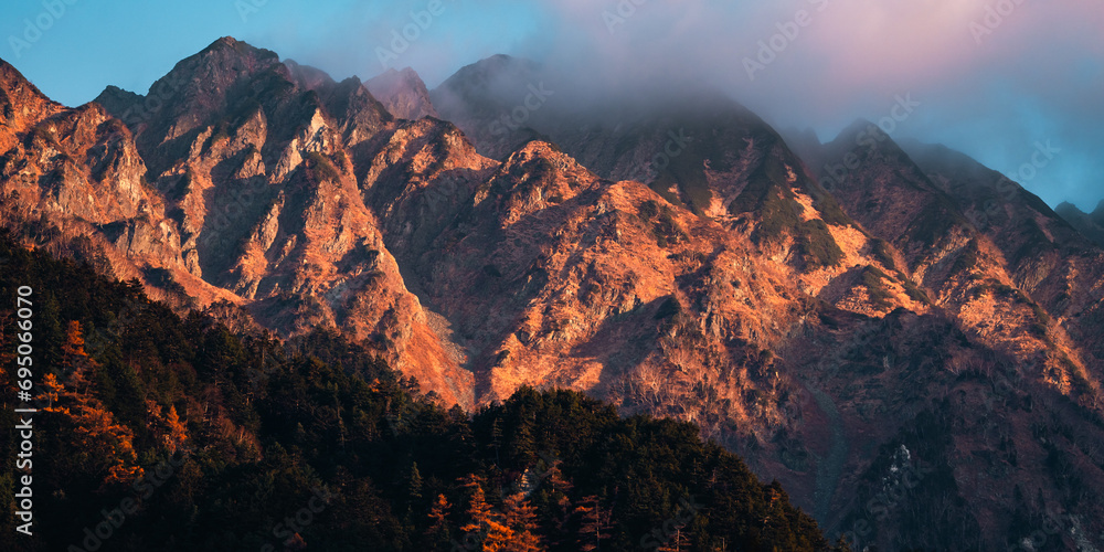 Naklejka premium Nature mountain landscape panorama view with snow, travel in Japan forest peak scenic with blue sky and winter white cloud, beautiful tree and cold ice scenery, outdoor hiking vacation in Kamikochi