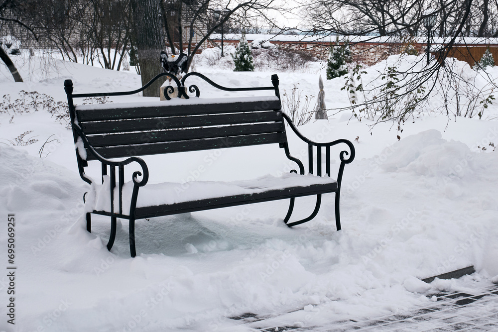 Snow-covered bench in a winter park