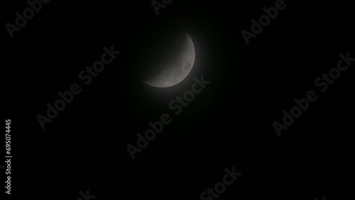 Tokyo, Japan - December 18, 2023: A half-moon covered with faint clouds in Japan
 photo