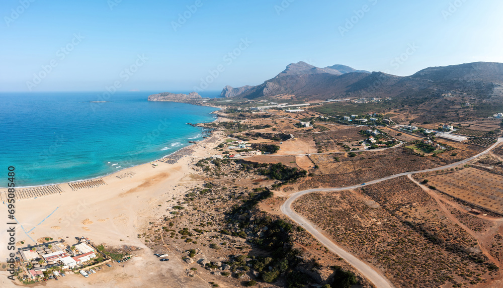 Crete island Greece. Aerial drone panoramic view of Falasarna beach, greenhouse, vast sea, blue sky.