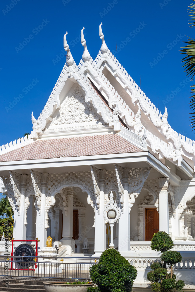 Beautiful Buddhist White Temple Wat Sawang Arom with green niwaki plants