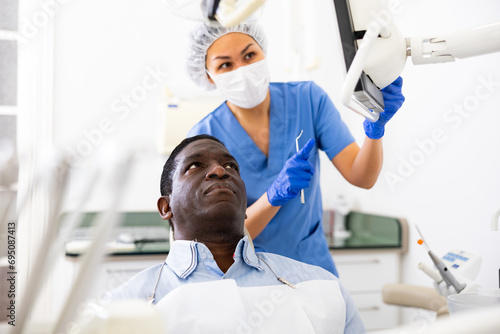 Doctor dentist shows patient an x-ray on computer