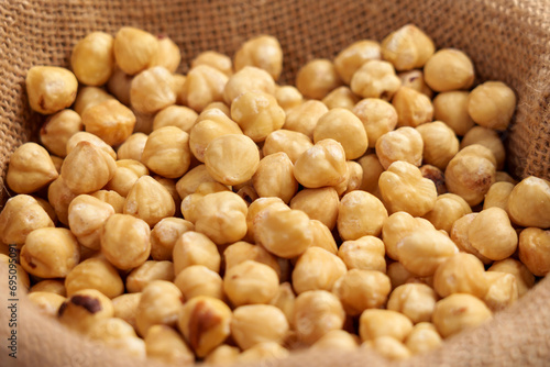Shelled hazelnuts in a sack close up. Peeled raw nuts.