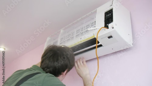 Worker in uniform sets air conditioning. Time lapse. photo