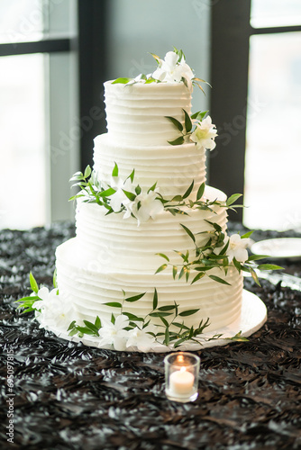 Modern white wedding cake with greenery formal black silver