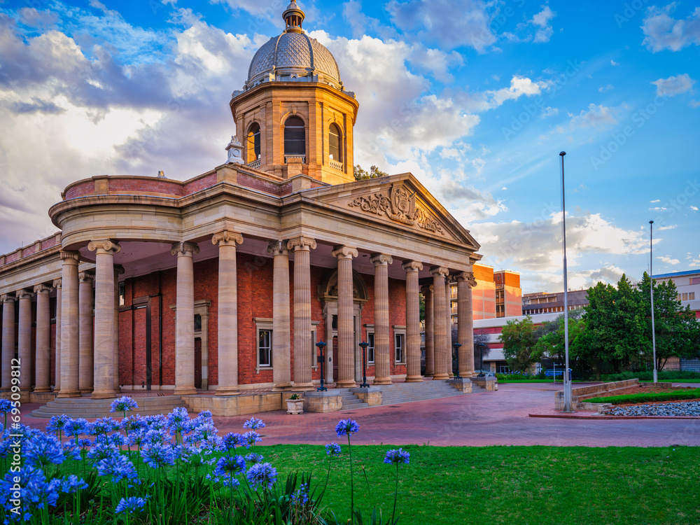 Fourth Raadsaal historic building with garden and flowers during sunset, Free State, Bloemfontein, South Africa
