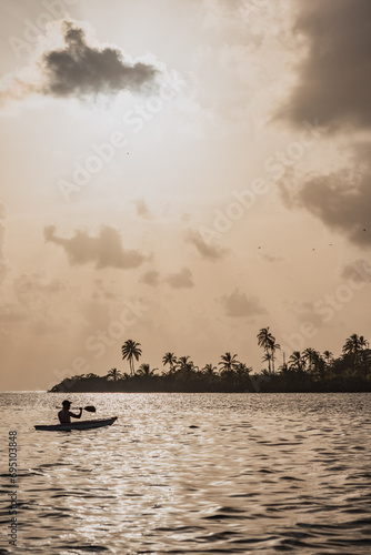 Man kayaking during sunset in a calm sea